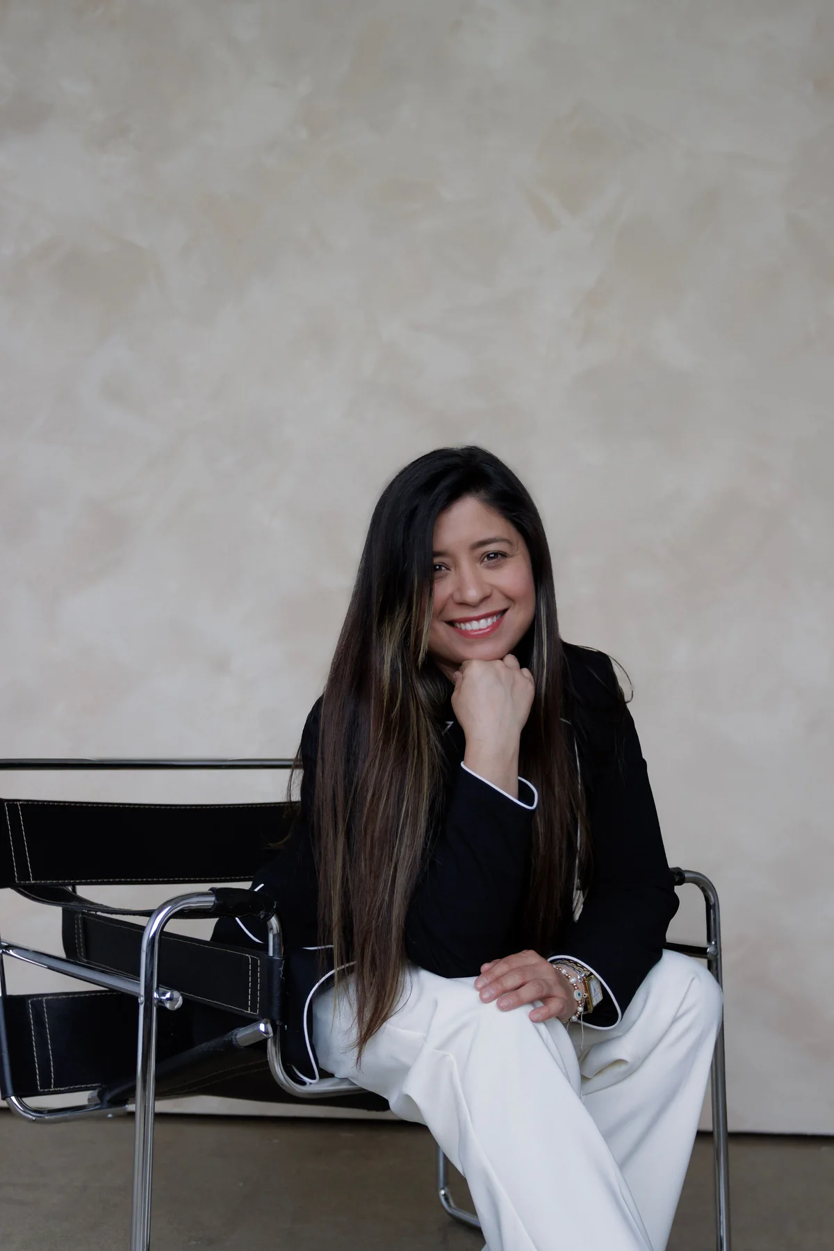 Maria Rojas sitting in a chair and smiling